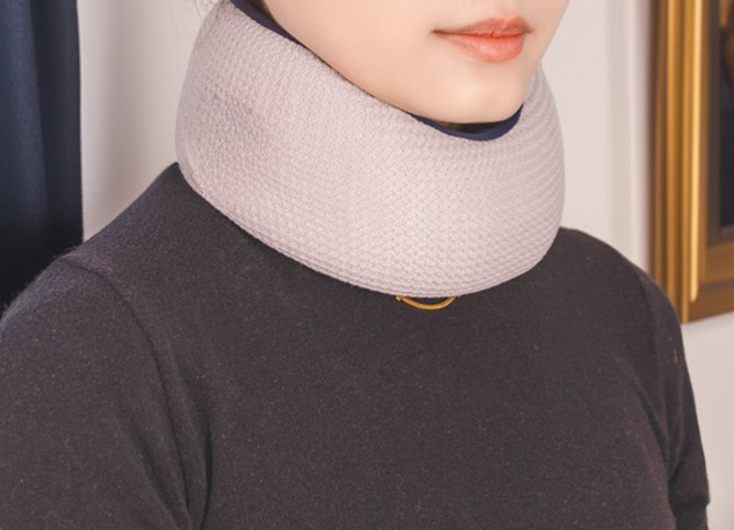 다기능 U자형 베개로 목 근육 이완 중인 사용자