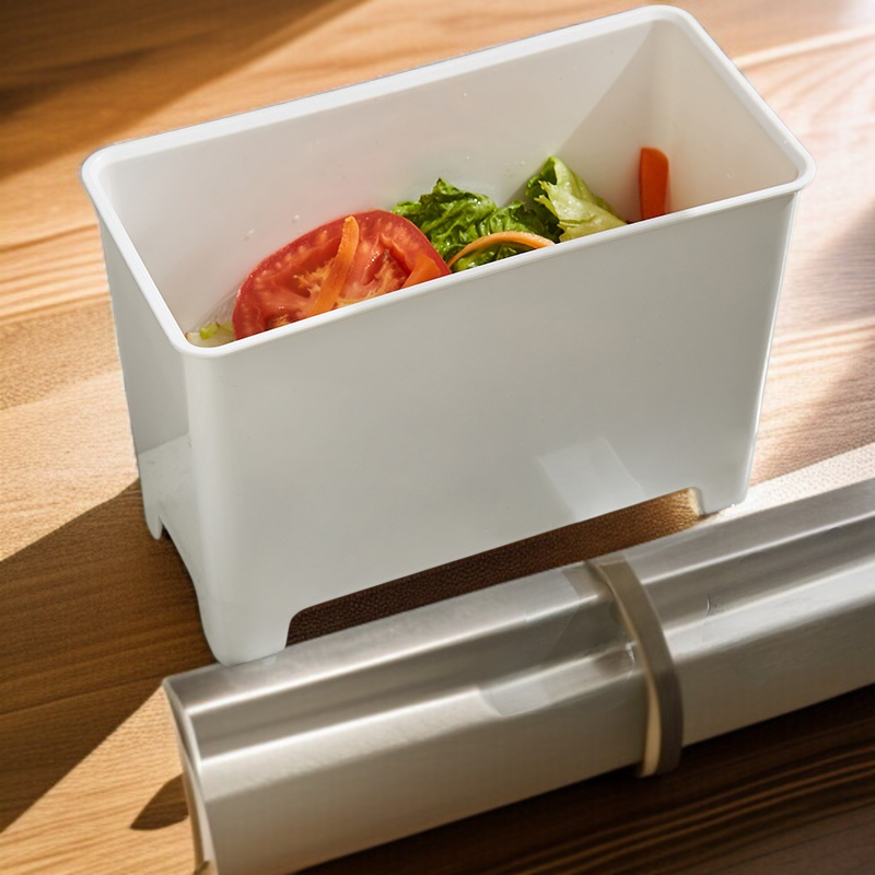 Kuchyňský odpadkový koš vedle dřezu na odkapávající kuchyňský odpad