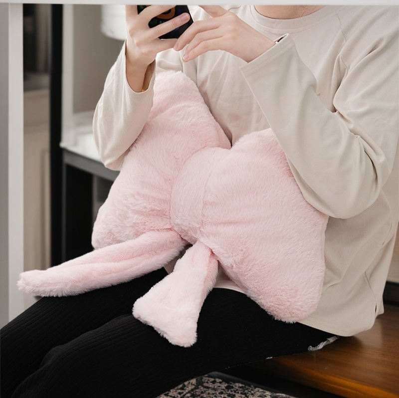 소파 위에 놓인 핑크 리본 베개 인테리어 연출