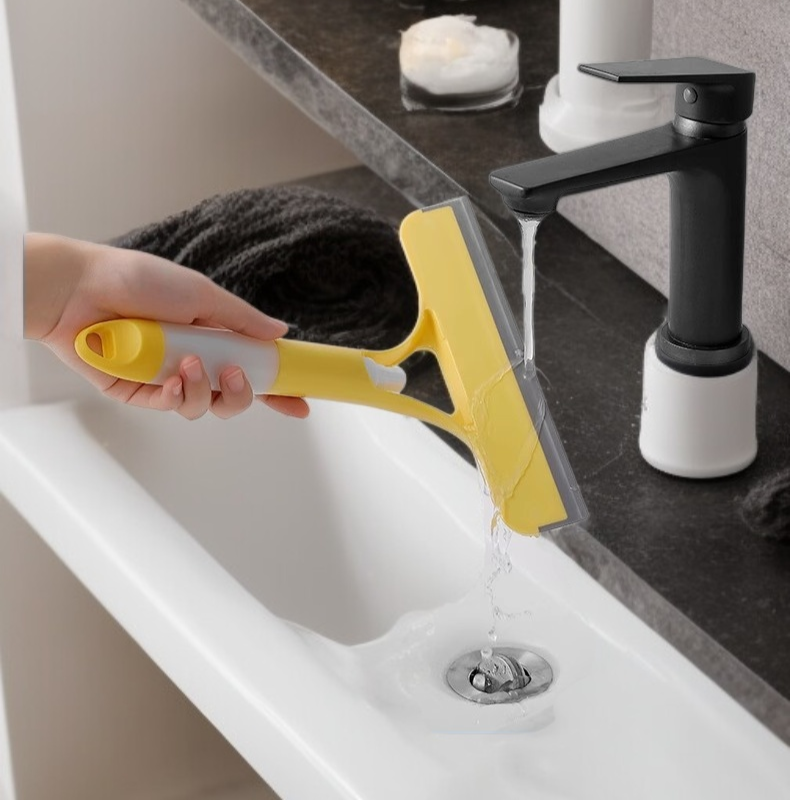 스크레이퍼로 욕실 거울을 깨끗하게 닦는 장면