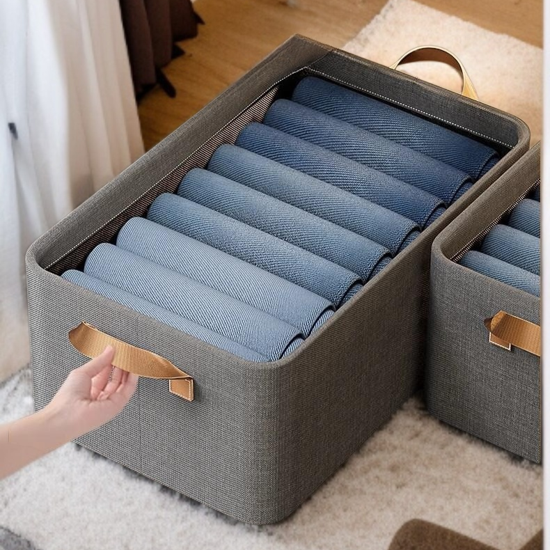 핸드헬드 옷을 가지고 헝겊 수납 바구니를 정리하다