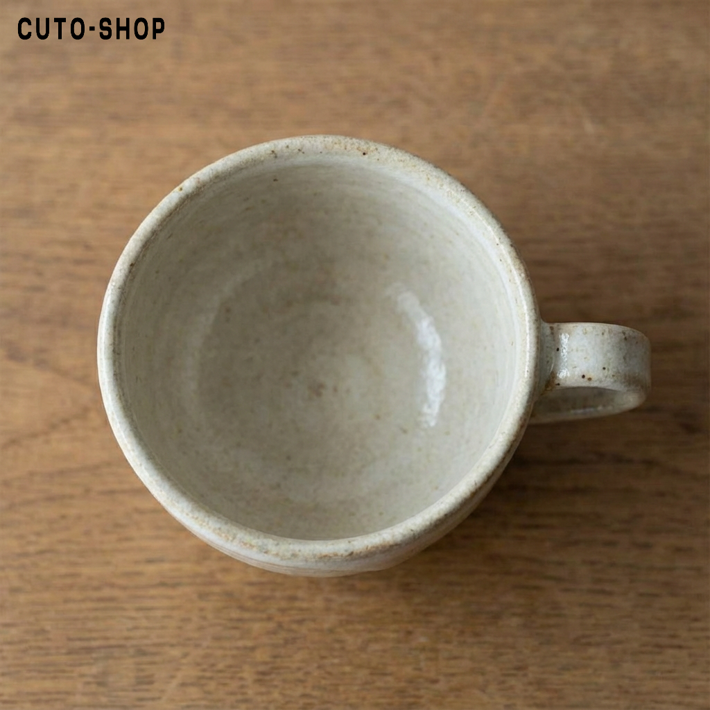 Taza de cerámica hecha a mano sobre mesa de madera