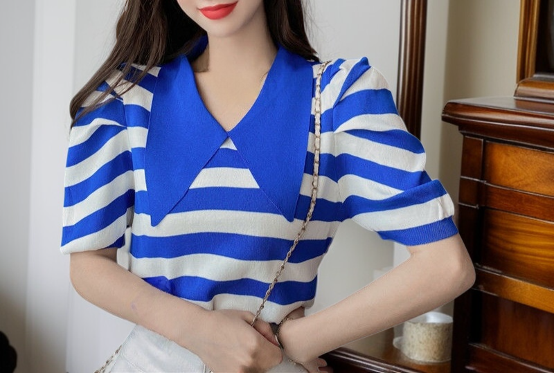 Modelo luciendo blusa de rayas con mangas voluminosas