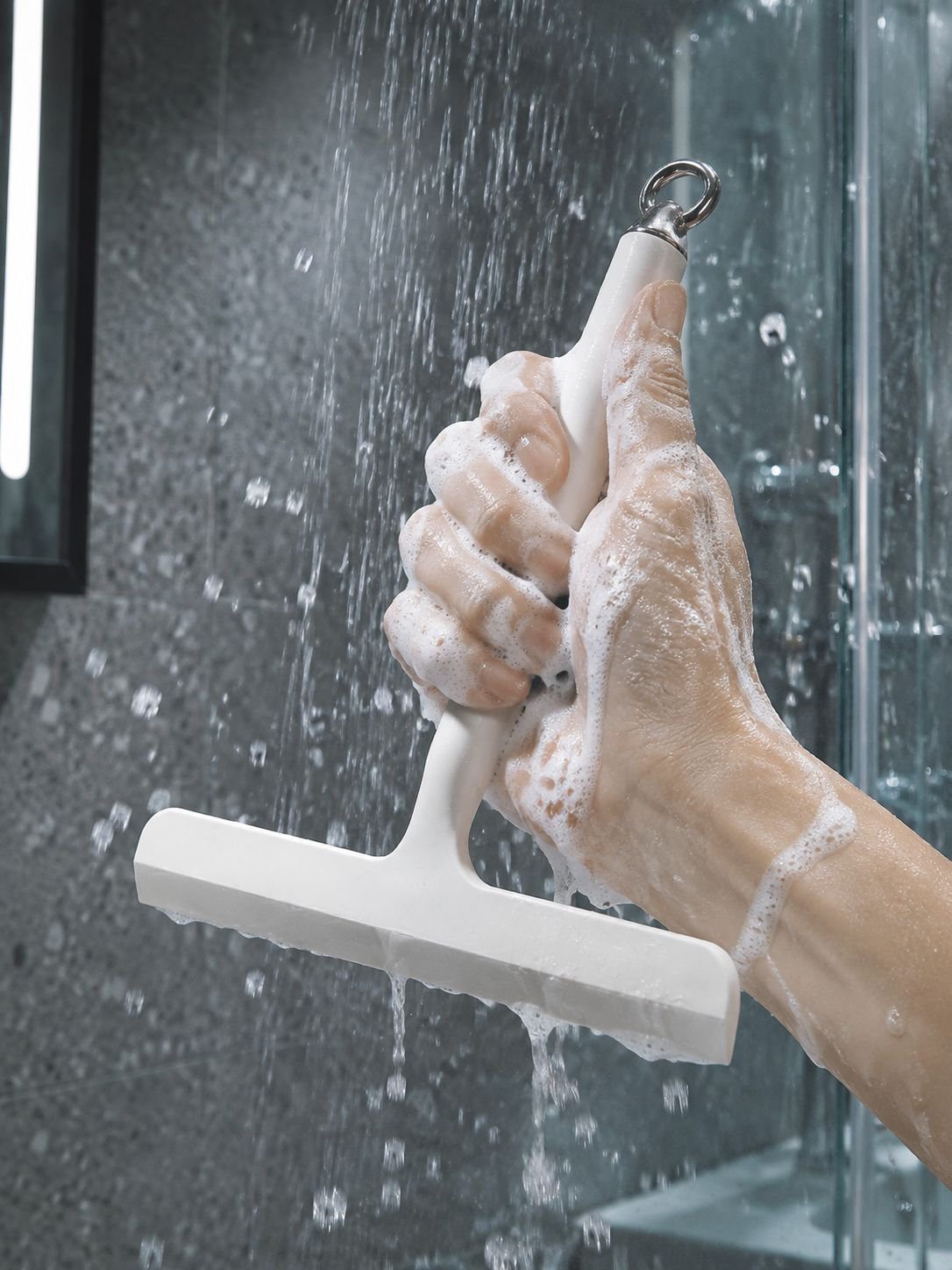 Close-up of plastic squeegee on shower glass